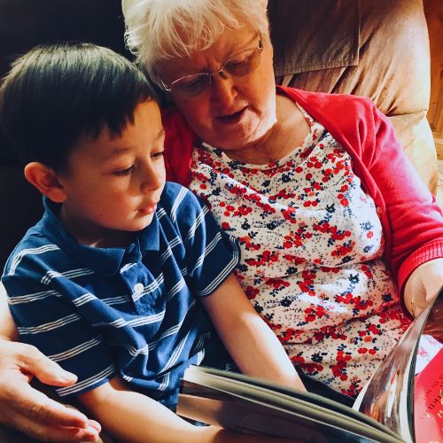 abuela leyendo un libro al nieto